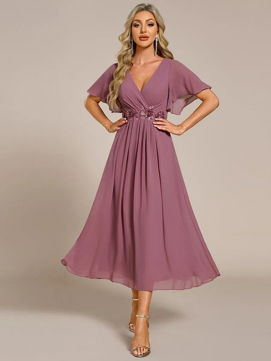 Robe d'invité de mariage mi-longue en mousseline à col en V avec appliques à la taille