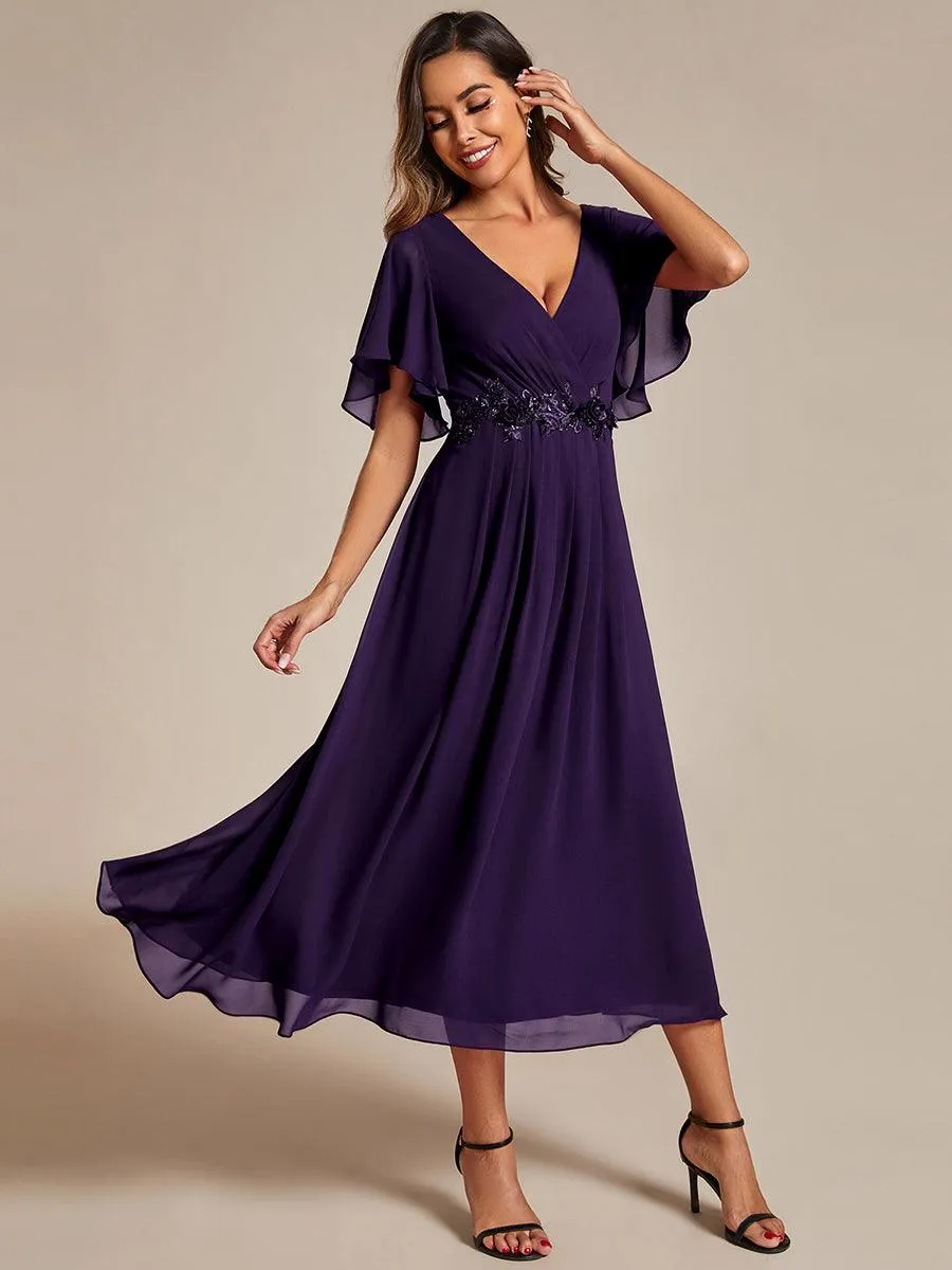 Robe d'invité de mariage mi-longue en mousseline à col en V avec appliques à la taille