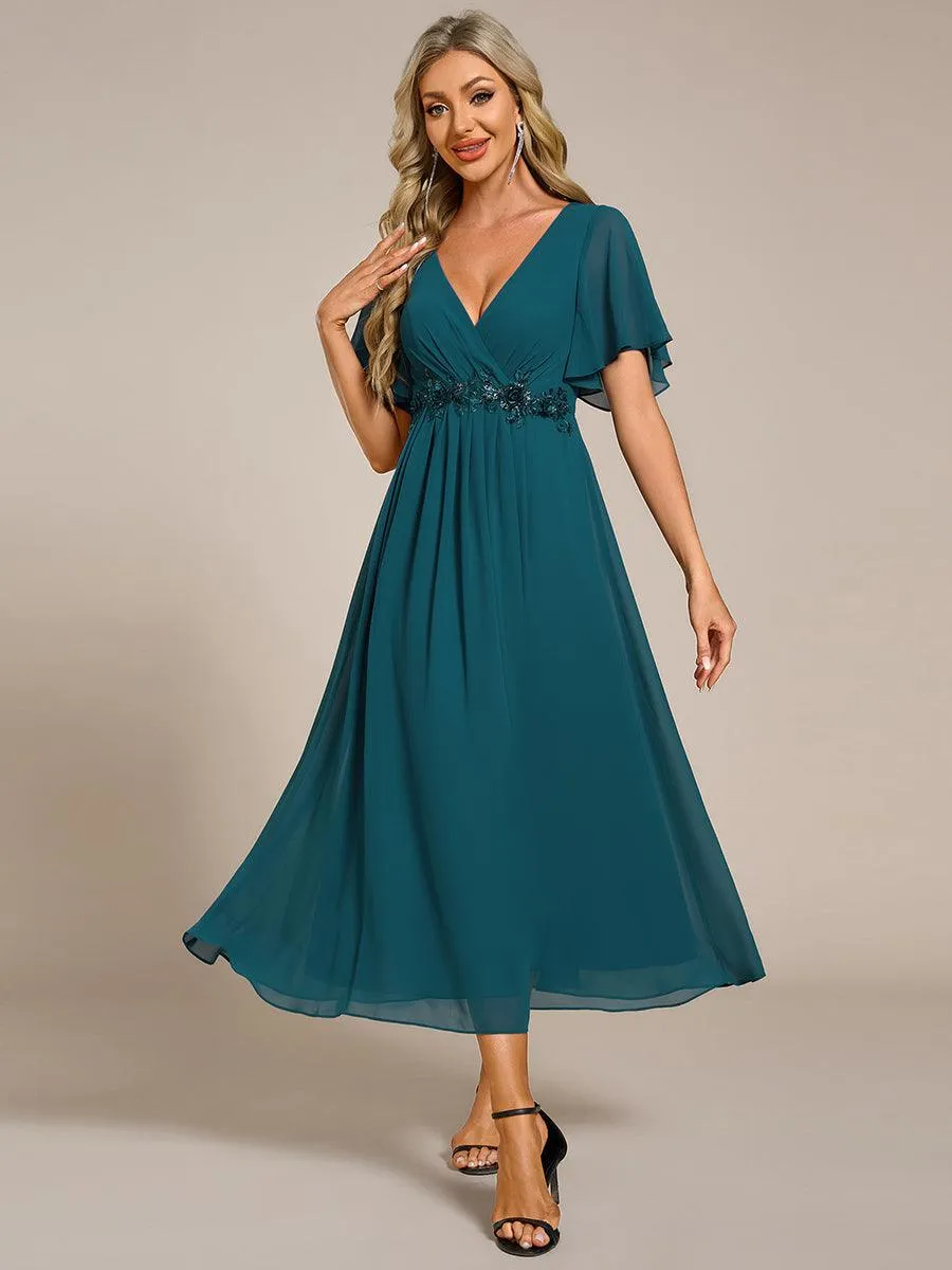 Robe d'invité de mariage mi-longue en mousseline à col en V avec appliques à la taille