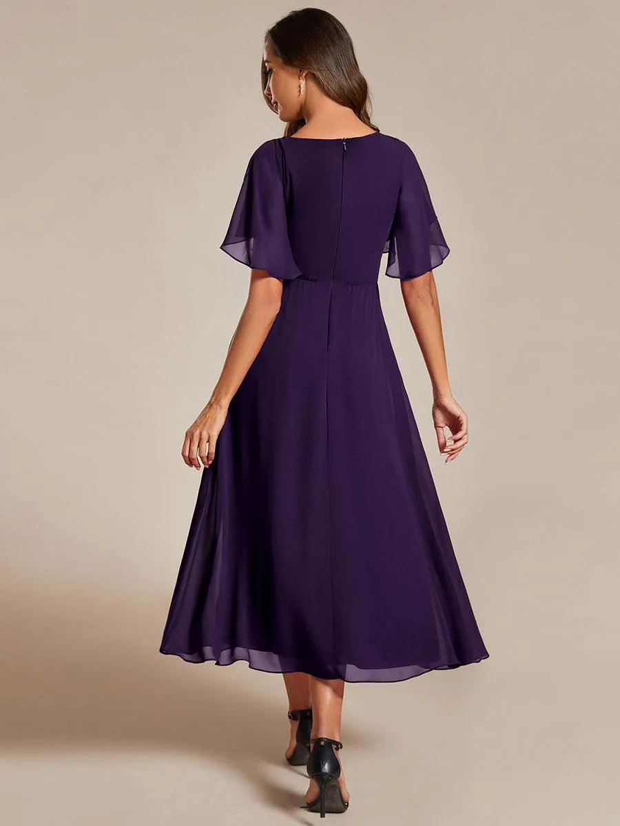 Robe d'invité de mariage mi-longue en mousseline à col en V avec appliques à la taille