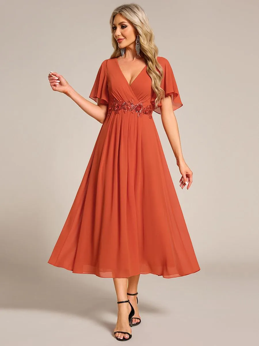 Robe d'invité de mariage mi-longue en mousseline à col en V avec appliques à la taille