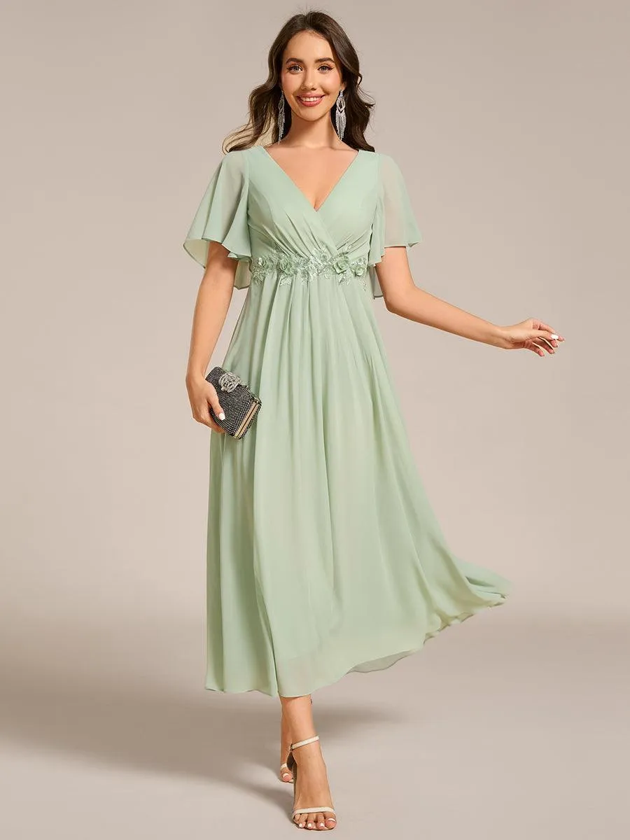 Robe d'invité de mariage mi-longue en mousseline à col en V avec appliques à la taille