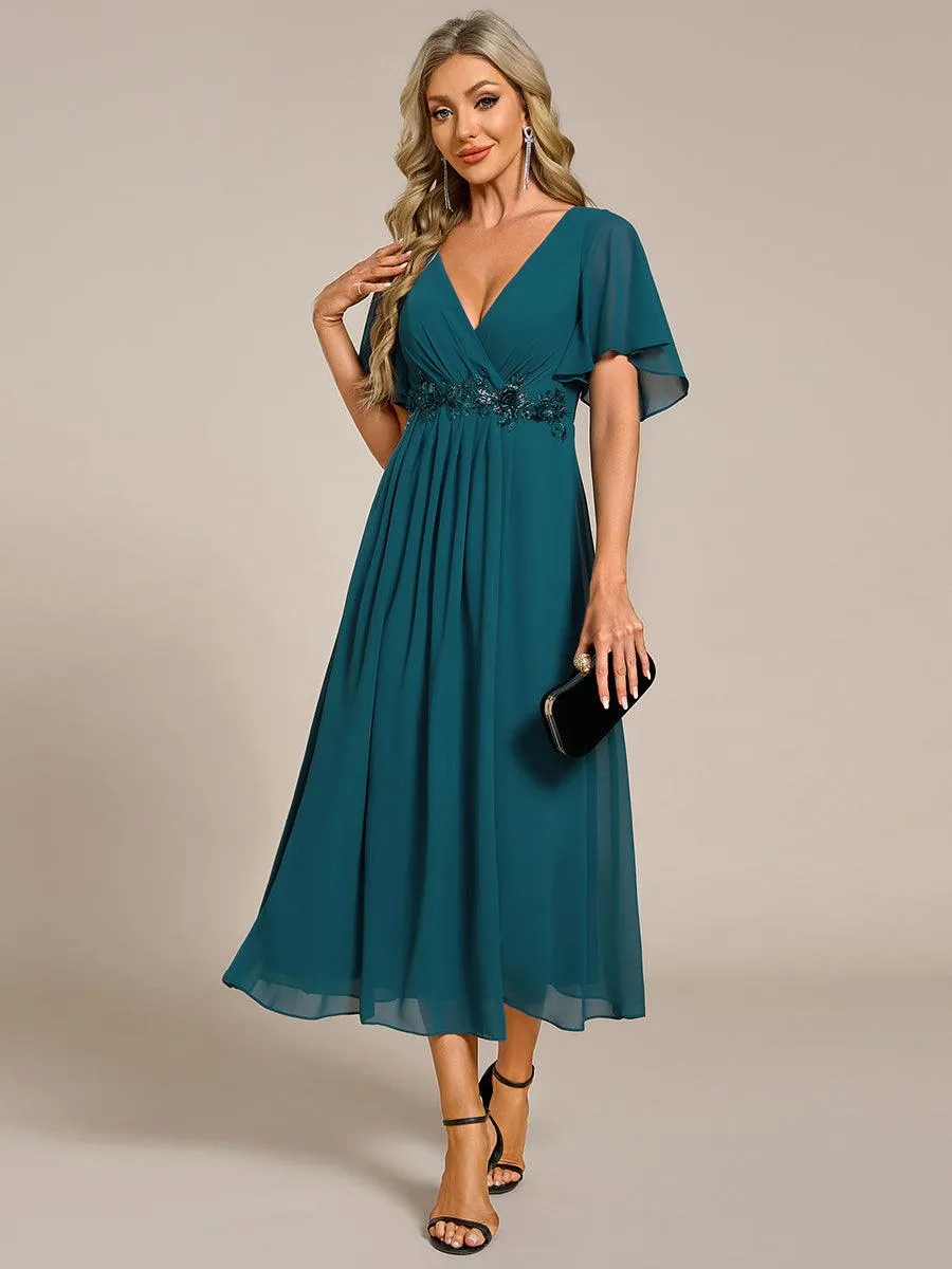 Robe d'invité de mariage mi-longue en mousseline à col en V avec appliques à la taille