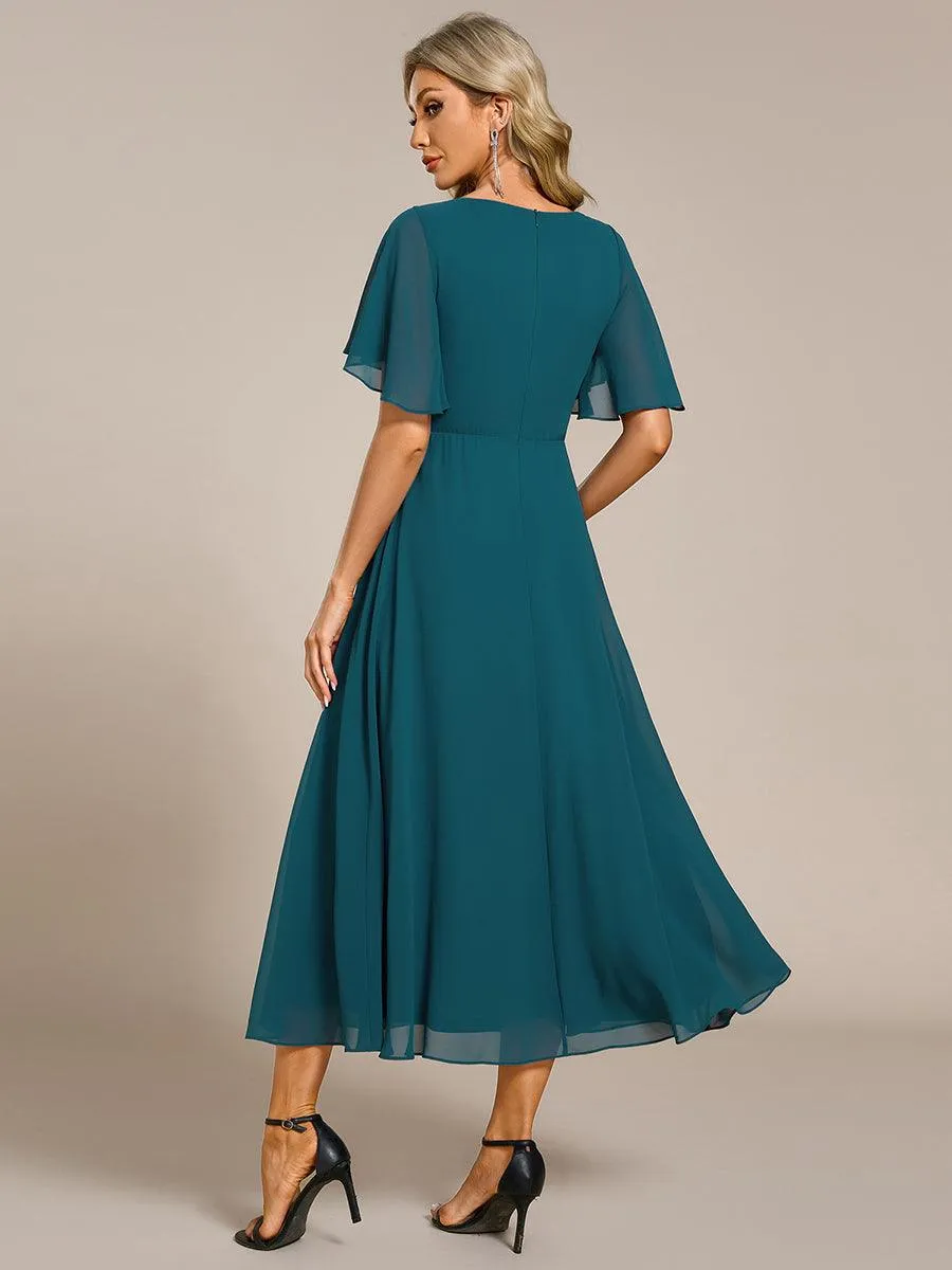 Robe d'invité de mariage mi-longue en mousseline à col en V avec appliques à la taille